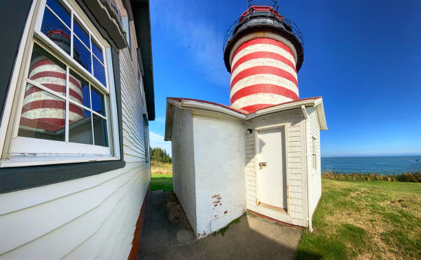 West Quoddy Head Lighthouse in Lubec, Maine  USA West Quoddy Head, in Quoddy Head State Park, Lubec, Maine, is the easternmost point of the contiguous United States. In 1808 a lighthouse was constructed at the site to guide ships through the Quoddy Narrows. The current tower, with distinctive red-and-white stripes, was constructed in 1858 and is an active aid to navigation. The 3rd order Fresnel lens is the only 3rd order and one of only eight Fresnel lenses still in use on the Maine Coast ta quoddy head state park stock pictures, royalty-free photos & images