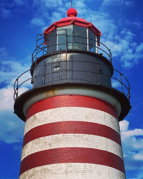 West Quoddy Head Lighthouse in Lubec, Maine  USA West Quoddy Head, in Quoddy Head State Park, Lubec, Maine, is the easternmost point of the contiguous United States. In 1808 a lighthouse was constructed at the site to guide ships through the Quoddy Narrows. The current tower, with distinctive red-and-white stripes, was constructed in 1858 and is an active aid to navigation. The 3rd order Fresnel lens is the only 3rd order and one of only eight Fresnel lenses still in use on the Maine Coast tartrf de tv quoddy head state park stock pictures, royalty-free photos & images