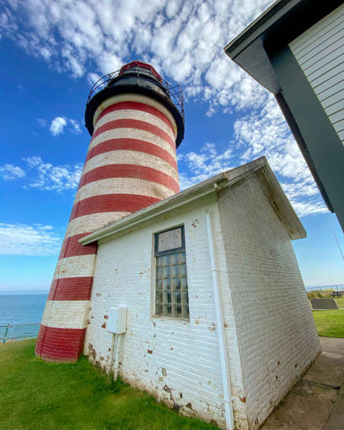 West Quoddy Head Lighthouse in Lubec, Maine  USA West Quoddy Head, in Quoddy Head State Park, Lubec, Maine, is the easternmost point of the contiguous United States. In 1808 a lighthouse was constructed at the site to guide ships through the Quoddy Narrows. The current tower, with distinctive red-and-white stripes, was constructed in 1858 and is an active aid to navigation. The 3rd order Fresnel lens is the only 3rd order and one of only eight Fresnel lenses still in use on the Maine Coast tartrf de tve quoddy head state park stock pictures, royalty-free photos & images