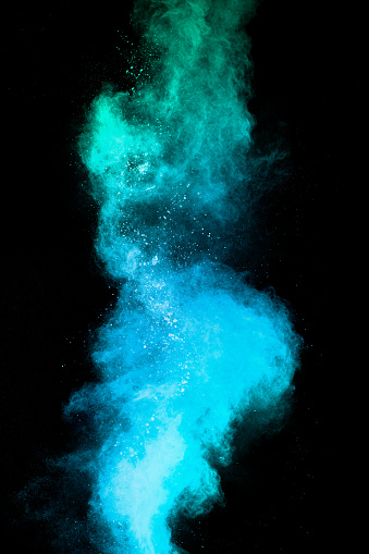 Blue powder explode cloud on black background.Launched blue dust particles splash on background.