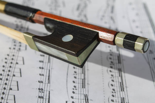 istock Violin bow on the background of notes 1279497342