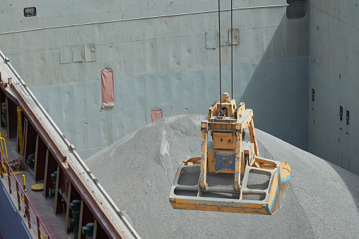 Loading and dischargind operation of bulk cargo bauxite on bulk carrier ship using grab bucket or clamshell.
