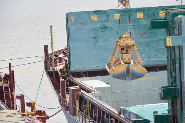 Loading and dischargind operation of bulk cargo bauxite on bulk carrier ship using grab bucket or clamshell.