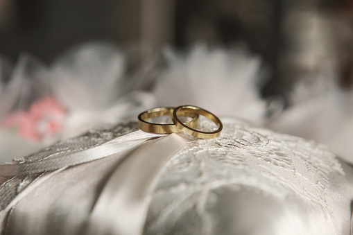 Gold wedding rings on pillow