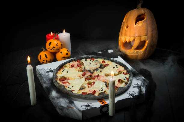 istock Ghost pizza with Halloween decoration: pumpkin jack o lantern, black bats, Candle lights on smoke background 1279502393