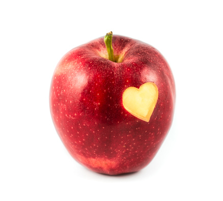 Red heart on ripe red apples, healthy food idea.