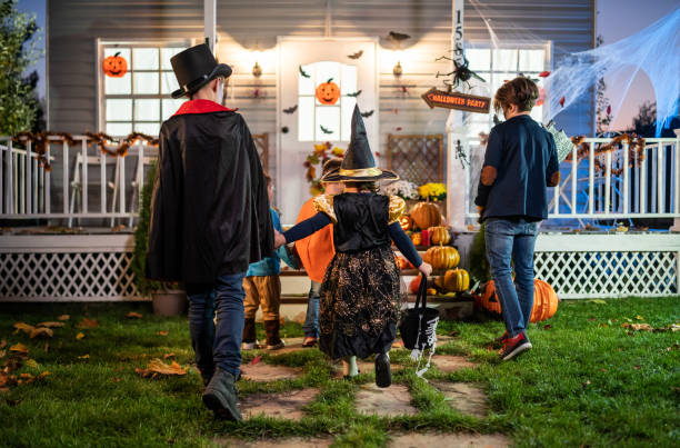 istock Young kids trick or treating at night during Halloween 1279510273