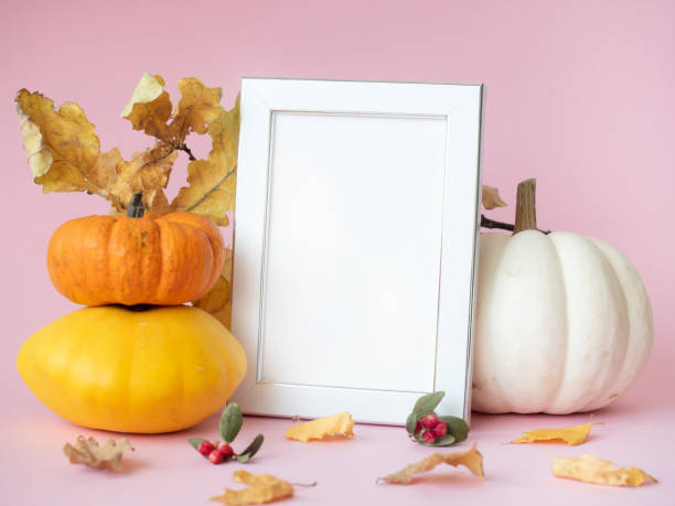 istock Empty white photo frame with autumn leaves and pumpkins around 1279510596