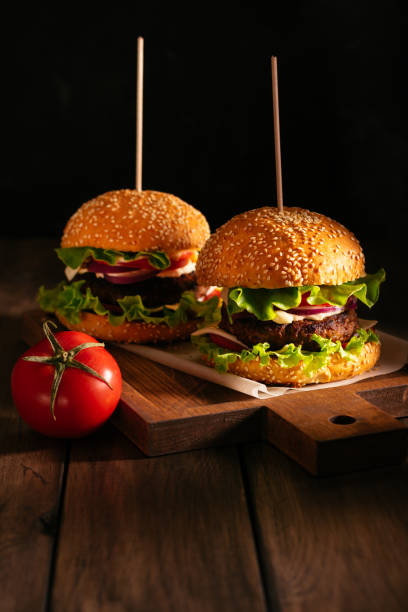 istock Two burgers on a wooden board 1279514005