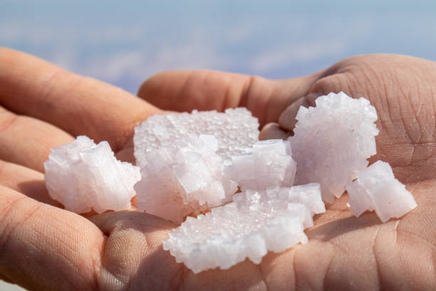 istock Hand holding salt crystals with blurred blue close-up 1279514037