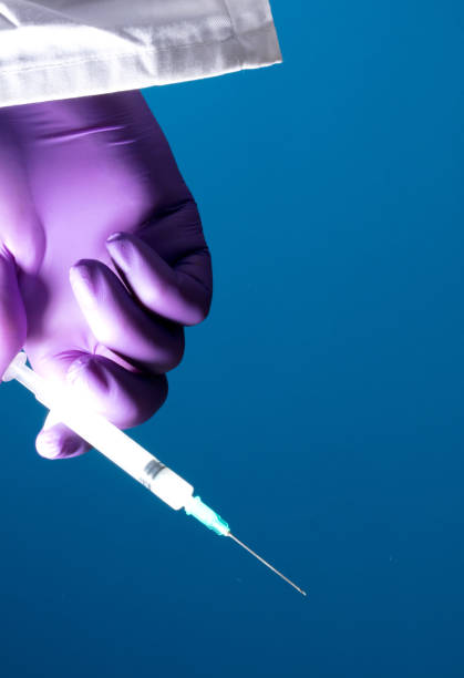 istock syringe in doctor's hand, blue background 1279517328