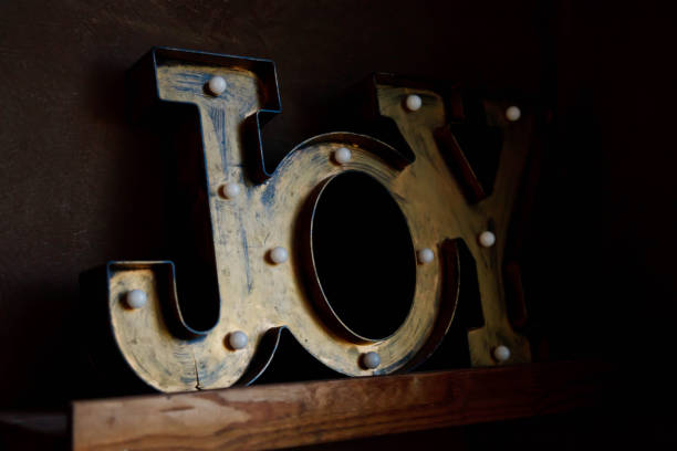 istock Tin letters forming word JOY on dark brown wall background 1279521150