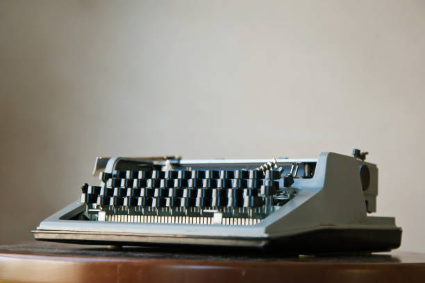istock Old classic retro typewriter on dusty Desk against beige wall background 1279521180