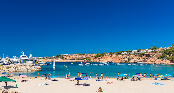 PORT ADRIANO, MALLORCA, SPAIN - 23 July 2020 - Tourists enjoying summer day on the popular city beach.