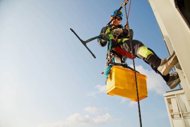 istock Industrial mountaineering worker hangs over residential building while washing exterior facade glazing 1279522470