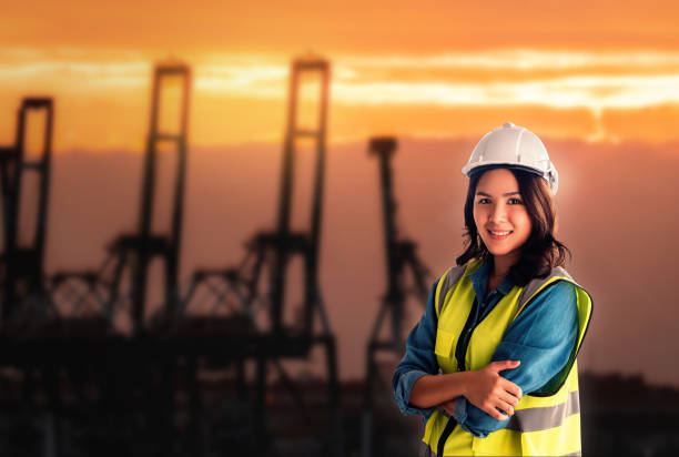 istock Female engineer is standing infront sea port cargo crane harbor terminal. 1279524710