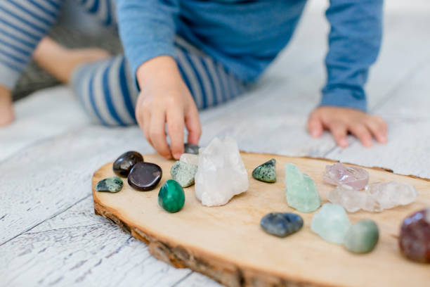 istock Child playing with stones (crystals) on a wooden board 1279524998