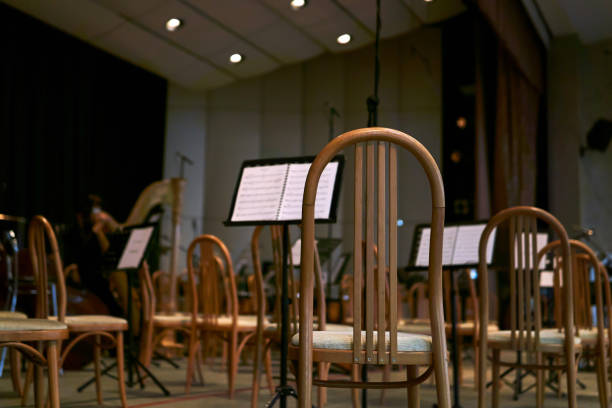 empty stage with chairs and musical scores before a symphony orchestra performance