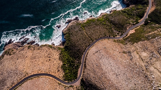 Aerial view over a coastal road near False Bay in Cape Town, South Africa. Road winds it's way along the coastline.