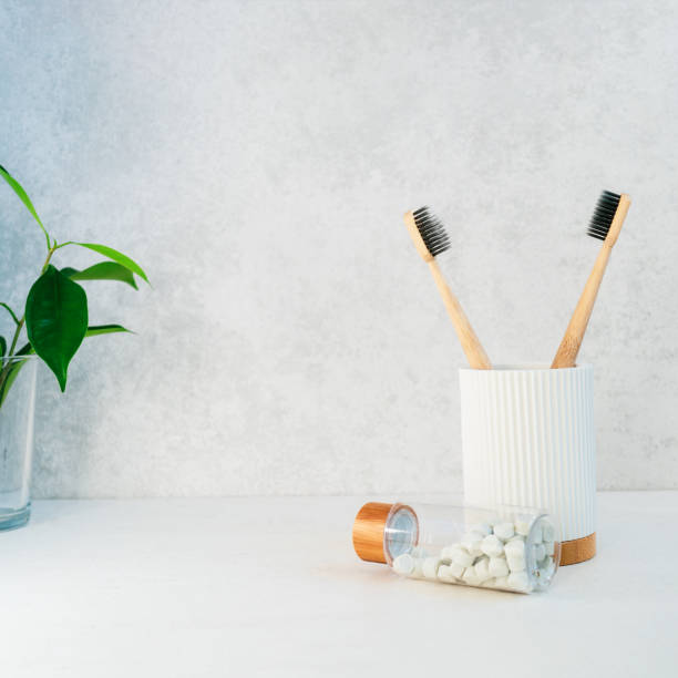 istock Zero waste bathroom items. Bamboo toothbrushes in recycling material holder, natural mouthwashing tabs and fresh green plants in glass. Oral care essentials. Eco-friendly home. Minimalism. Copy space. 1279530375