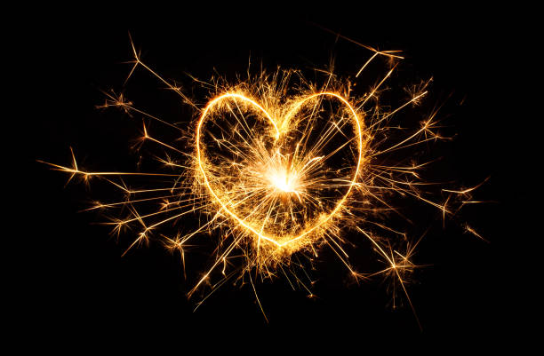 istock Sparkling golden heart isolated on black background. 1279531530