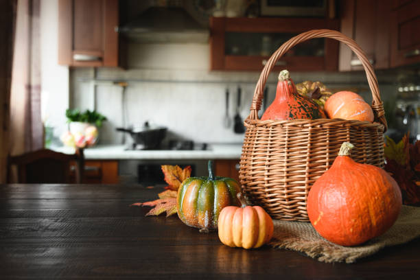 istock Blurred kitchen with pumpkins on table top and funny child dressing as ghost for Halloween party. 1279535936