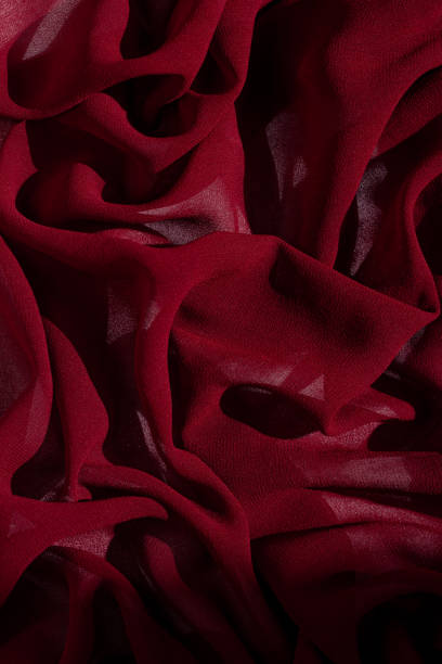 istock Smooth elegant burgundy chiffon fabric abstract background. Dark red wine silk luxury cloth texture light surface design 1279535970
