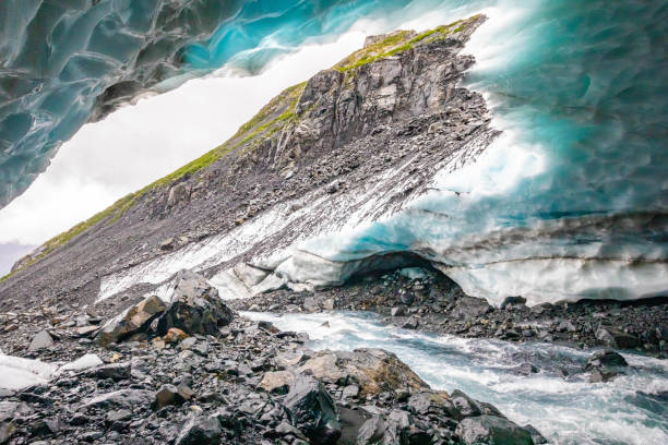 Scenic glacier ice caves with river flowing out from inside nobody