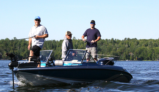 Tres hombres en un barco azul, pescando 2. photo