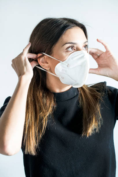istock YOUNG WOMAN PUTTING ON HER PROTECTIVE MASK 1279542168