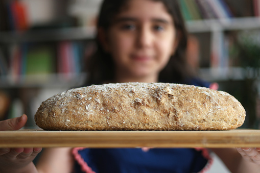 Girl hand holding hot freshly baked bread