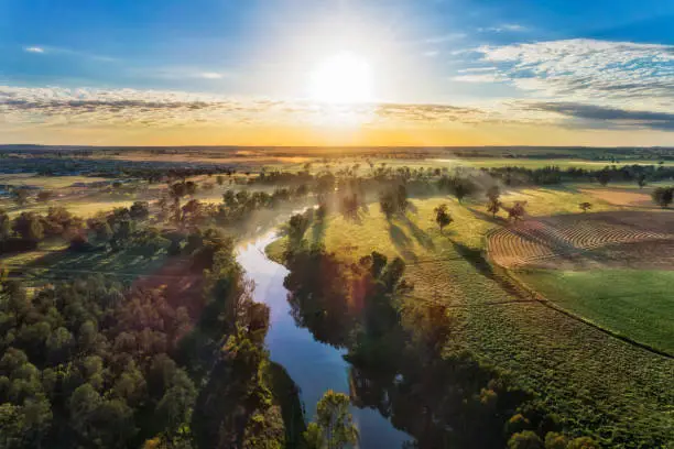 Macquarie river in Dubbo near Dundullmal homestead and farm fiels in aerial sunrise scenic view.