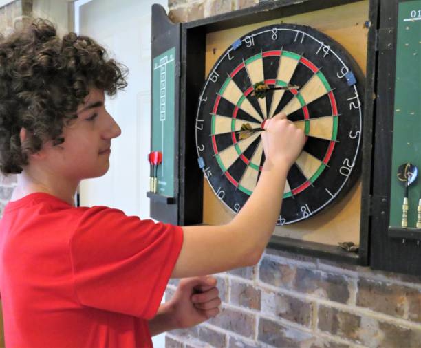 ティーン少年はダーツを果たしています - dartboard darts scoreboard leisure games ストックフォトと画像