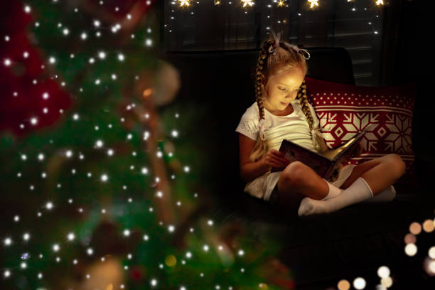 istock A girl reading a book on a sofa and a decorated Christmas tree 1279558443