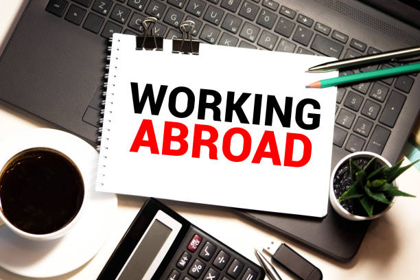 istock businesswoman holding a card with text WORKING ABROAD 1279561799