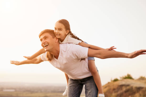 istock Happy father playing with girl in meadow 1279564463