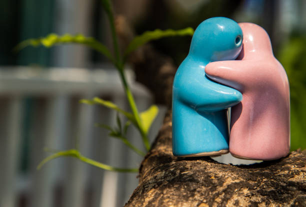 istock Blue and pink ceramic couple dolls hug with each other on the tree. 1279564762