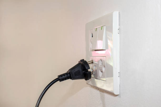 istock The dangers of using electricity in your home or office include a black plug that is not completely plugged into the white wall. 1279566220