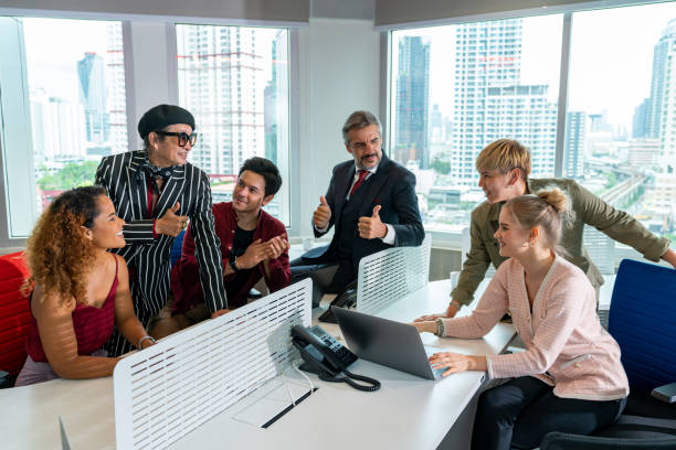 Group of cheerful multiethnic business people, company staff, and workers in a modern office Group of cheerful multiethnic business people, company staff, and workers in a modern office. A successful diverse team of LGBT encourages one another at the workplace. Concept of gender equality. transgender person in office stock pictures, royalty-free photos & images