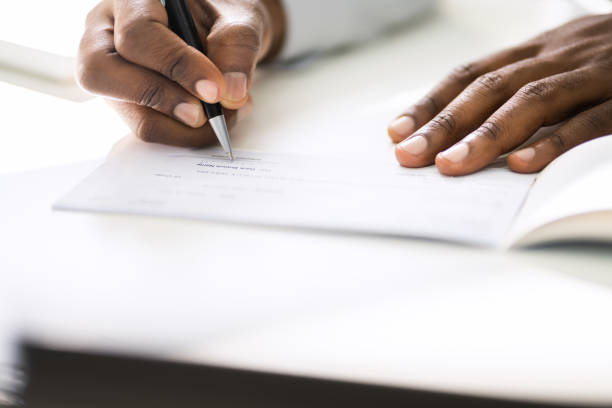 istock African American Writing Cheque. Signing Paycheck 1279567144