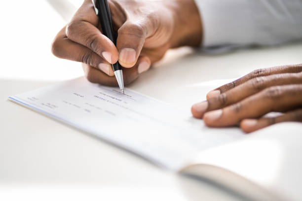 istock African American Writing Cheque. Signing Paycheck 1279567146