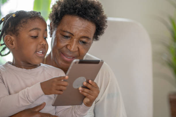 istock Grandmother using technology with granddaughter 1279567290