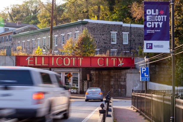 Welcome to Ellicott City sign written in large capital letters on side of the B&O railroad bridge at the entrance of city Ellicott City, MD, USA 10/07/2020: Welcome to Ellicott City sign written in large capital letters on side of the B&O railroad bridge at the entrance of city. Old houses and cars passing by are seen. ellicott city stock pictures, royalty-free photos & images