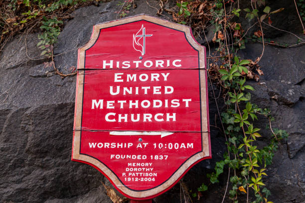 Red vintage wooden board sign hanging on a stone wall that shows the direction of Historic Emory United Methodist Church Ellicott City, MD, USA 10/07/2020: Red vintage wooden board sign hanging on a stone wall that shows the direction of Historic Emory United Methodist Church which was founded in Ellicott City in 1837 ellicott city maryland stock pictures, royalty-free photos & images