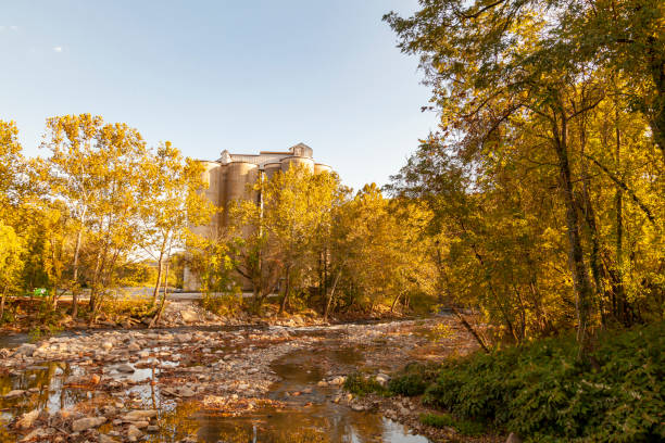 Patapsco river at Ellicott City,MD in autumn. View from the bridge over Patapsco river at Ellicott City,MD in autumn. Image features the river with a rocky bed, trees with autumn colors, fallen leaves and a historic flour mill behind trees. ellicott city maryland stock pictures, royalty-free photos & images