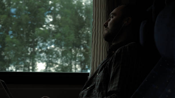 istock Man with headphones in the train looking in window 1279579613