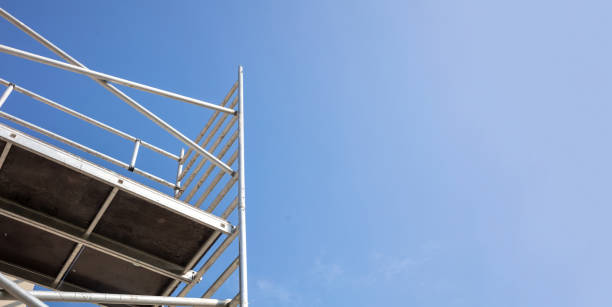 Scaffolding, metal mobile scaffold aginst blue sky background.