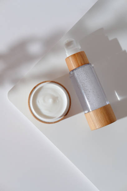 istock Eco friendly bamboo cosmetic packaging. Natural organic cream moisturizer and lotion on white podium. View from above. 1279585185