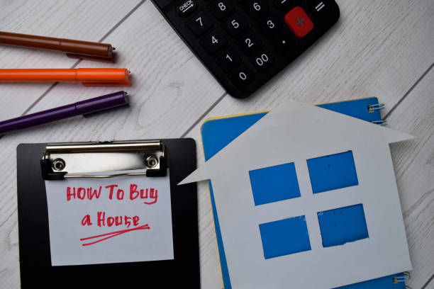 istock How To Buy a House text write on paperwork isolated on office desk. 1279585374