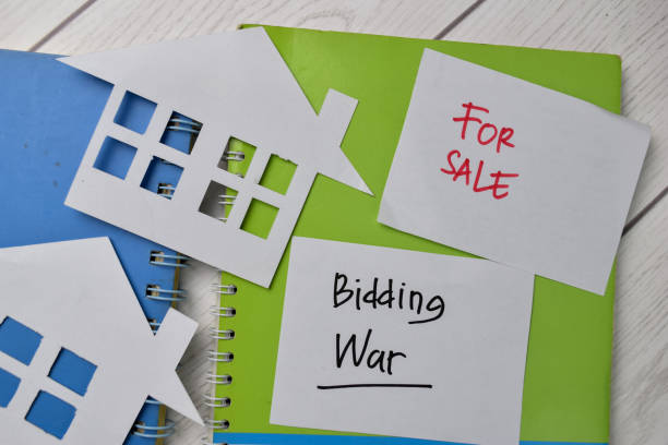 bidding war y house for sale escriben en notas adhesivas aisladas en office desk - bids fotografías e imágenes de stock